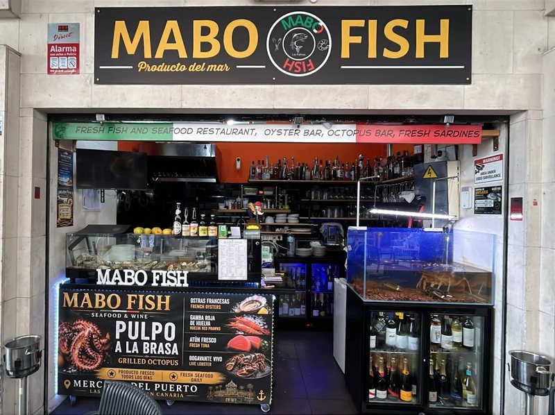 La vetrina di MABO Fish al Mercado del Puerto, con l’insegna e le bottiglie di vino